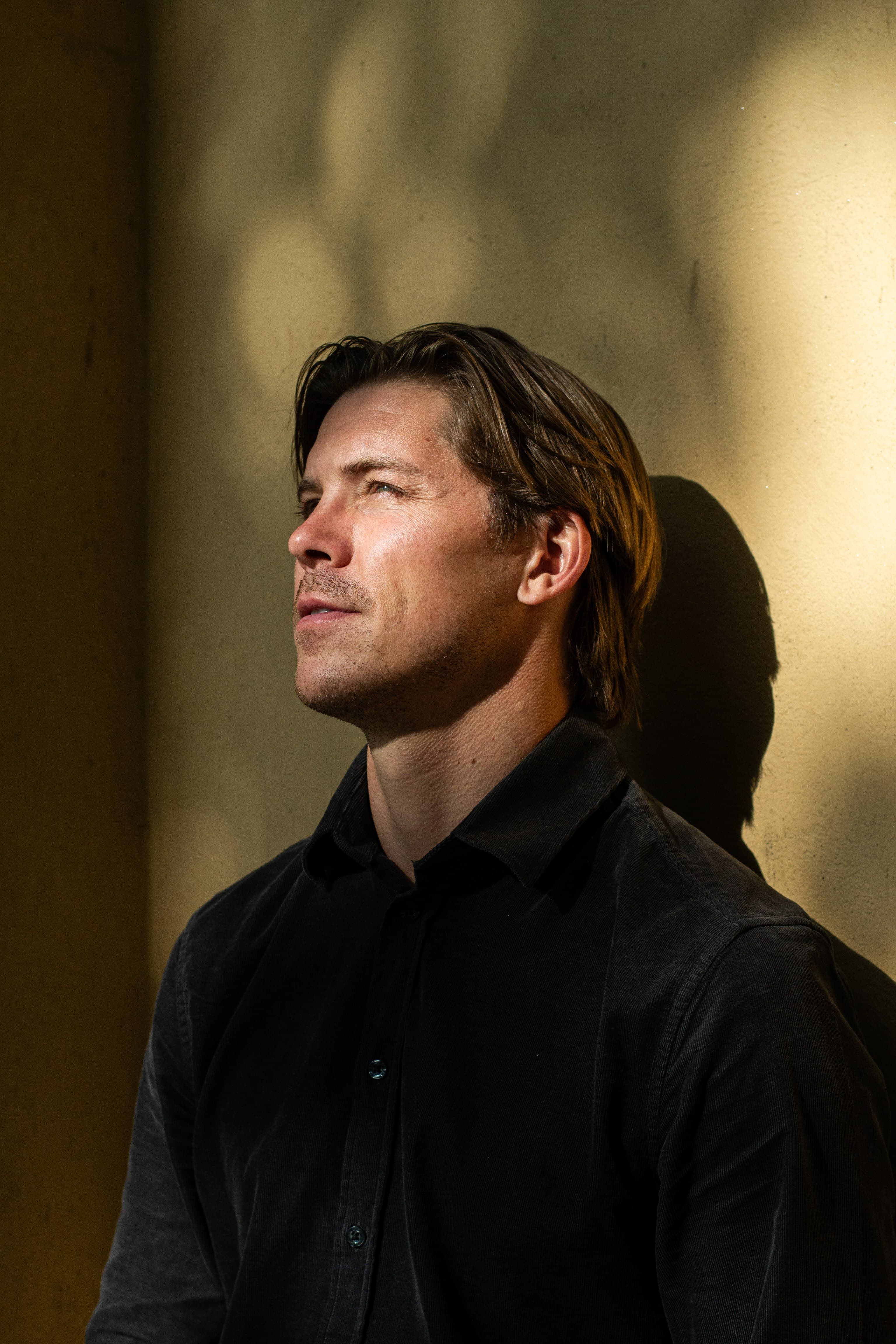 Jakko - cinematic profile against golden warm wall