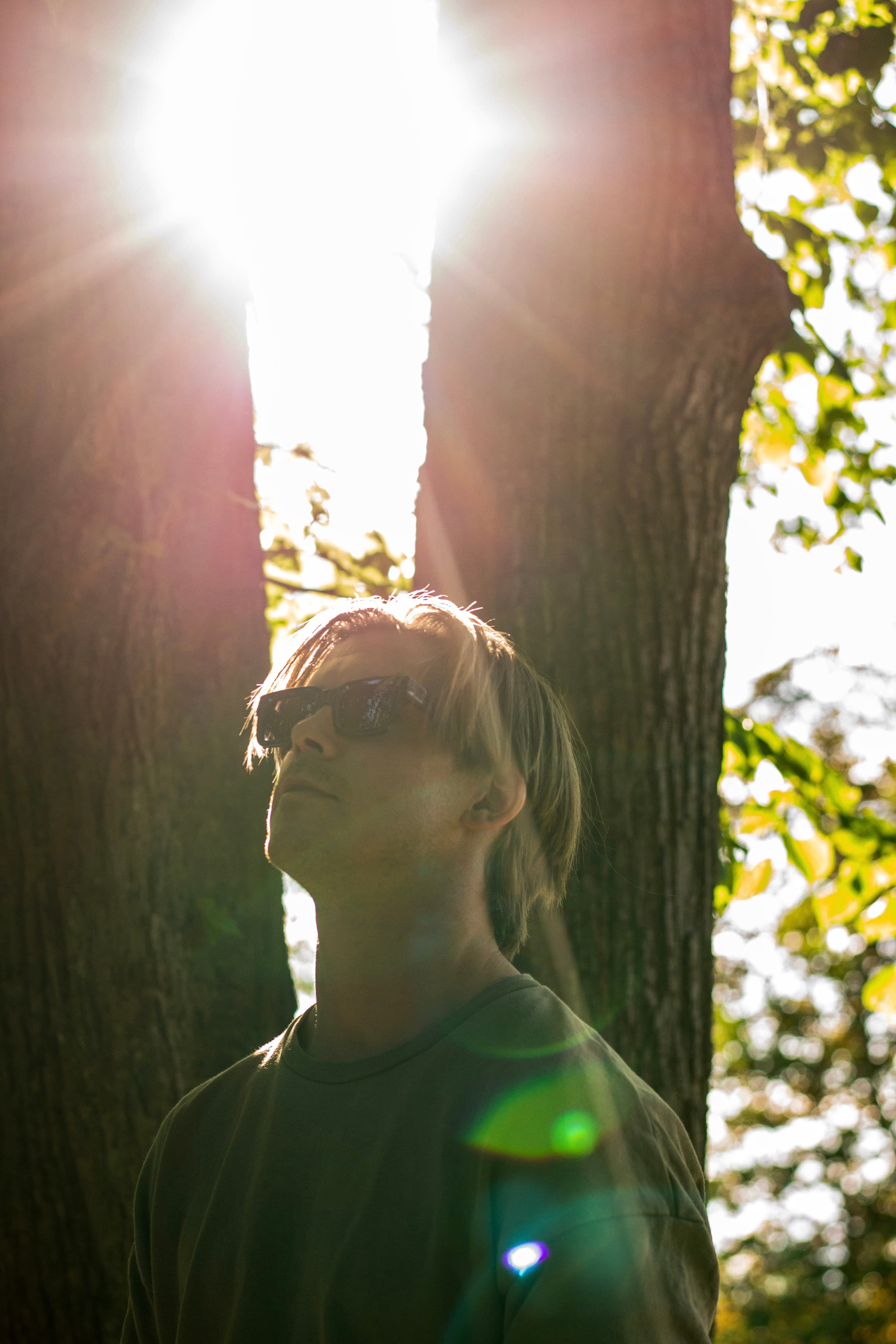Jakko - artistic outdoor shot with sun flare between trees